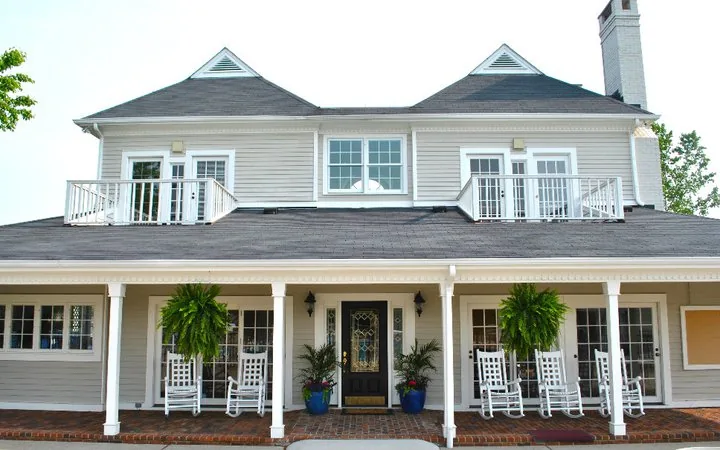 The clubhouse exterior seen from the lawn, with covered porches on both levels